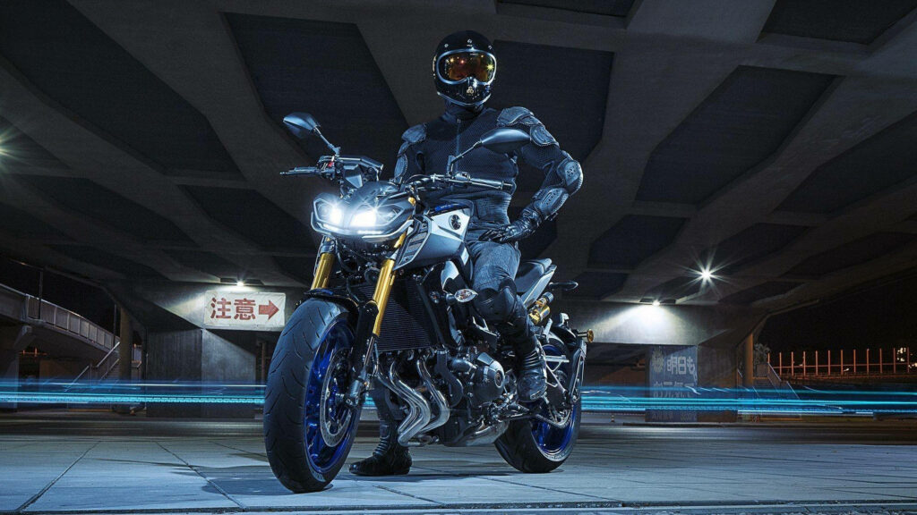 Dynamic Yamaha MT-15 Wallpaper: Rider in Bold Pose Under Urban Bridge