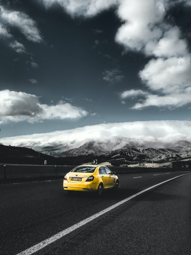 Dynamic Yellow Geely Car Wallpaper: Open Road Adventure Scene