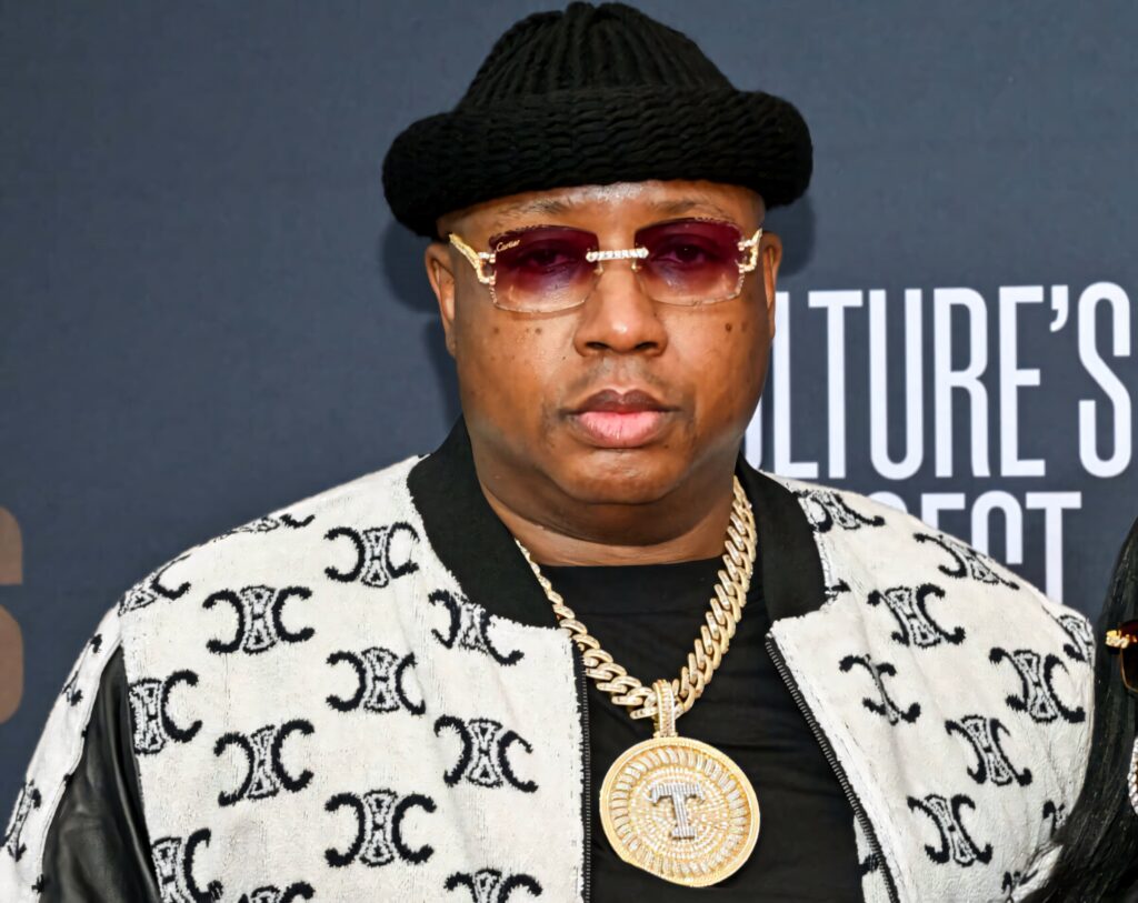 E-40 at event wearing patterned jacket gold chain sunglasses black knit hat hip hop style Wallpaper