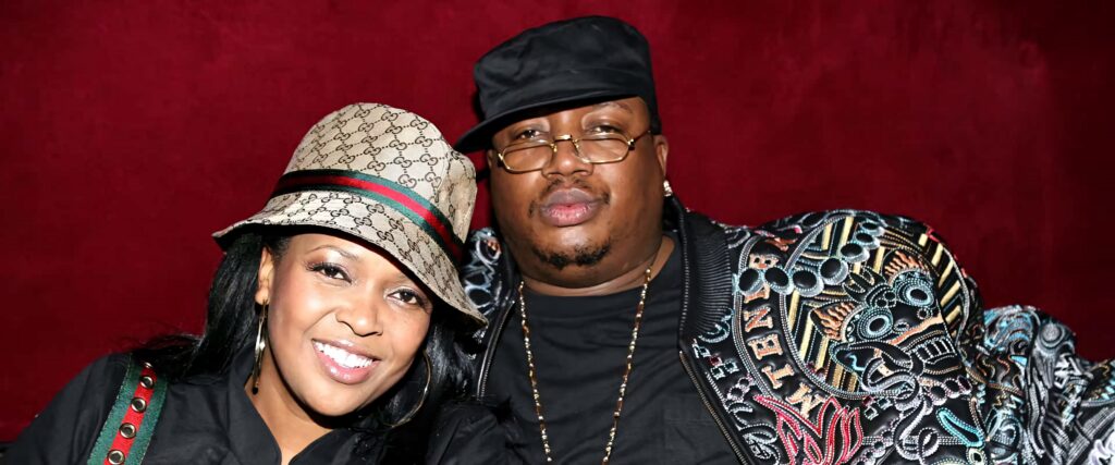 E-40 and Tracy Stevens in bold designer fashion against vivid red background confident style portrait Wallpaper