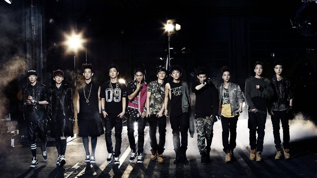 High-contrast EXO wallpaper with 12 members in edgy industrial streetwear and dramatic lights