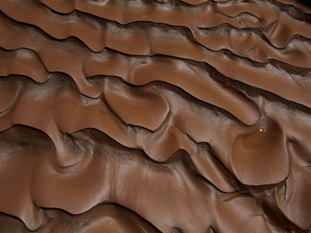 Earthy mud soil pattern wallpaper with flowing brown waves and organic textured landscape background