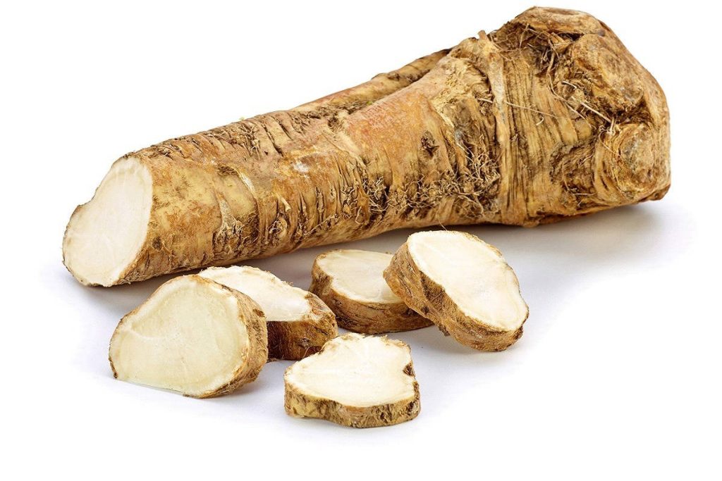 Whole horseradish root with fresh sliced pieces on white background high resolution studio photo Wallpaper