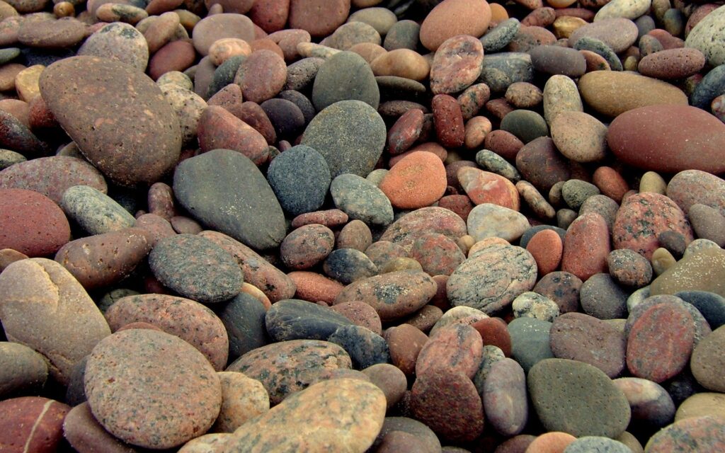 Smooth earthy toned stones mosaic wallpaper creating a calming natural riverbed texture background