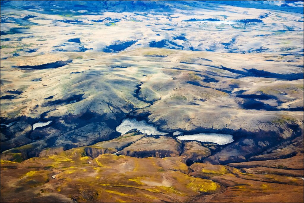 East Iceland landscape wallpaper with rolling hills valleys ochre green and blue rugged terrain