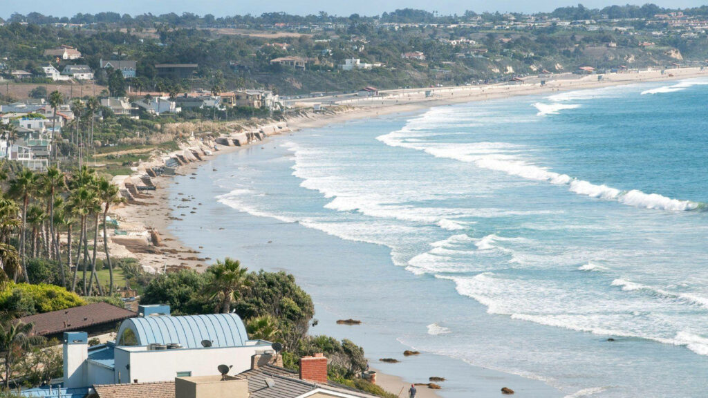 Malibu Beach from Above: Soaring above the Wavy Waters and Bustling Shoreline Wallpaper