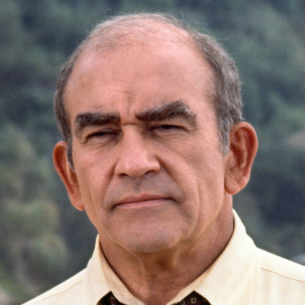 Close-up portrait of Ed Asner in yellow shirt with natural outdoor background and warm lighting Wallpaper