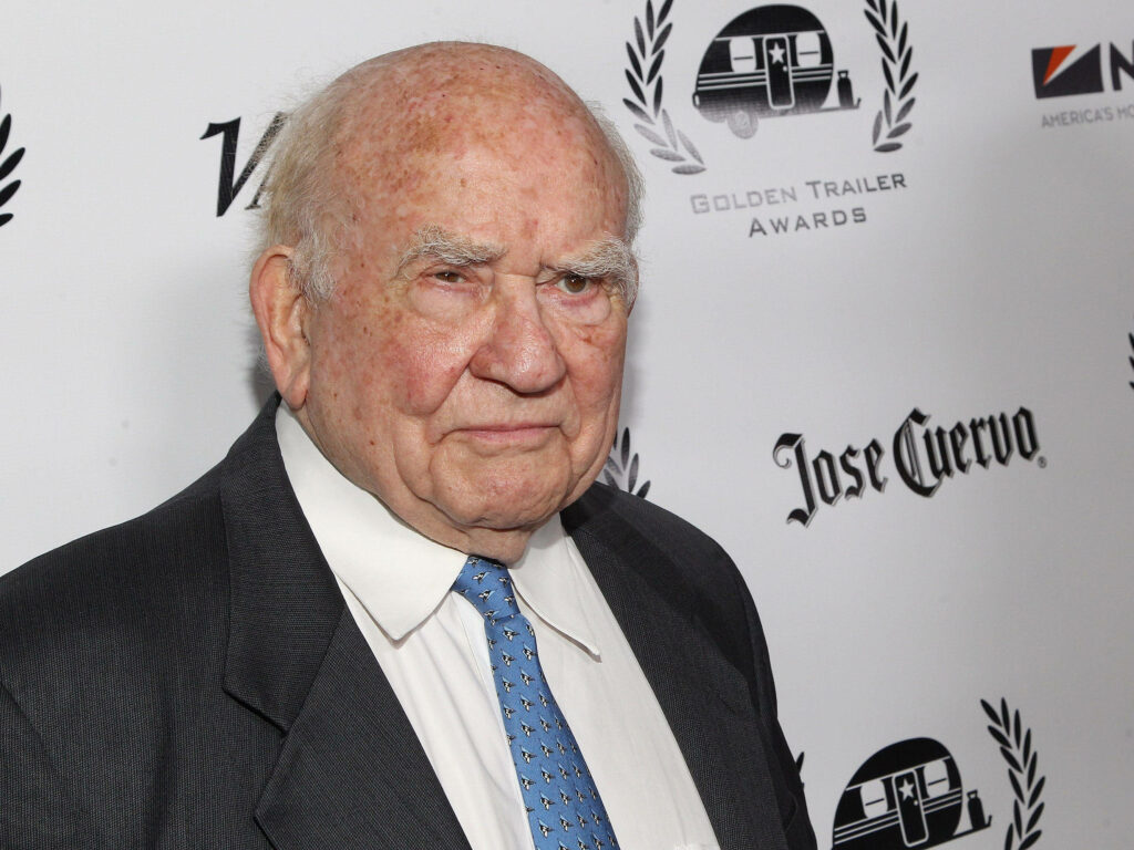 Ed Asner at high-profile event in formal suit blue patterned tie branded award backdrop wallpaper
