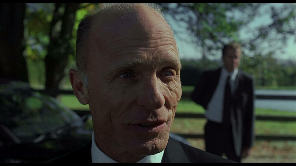 Ed Harris close-up intense expression History of Violence sharp suit sunlit natural background wallpaper