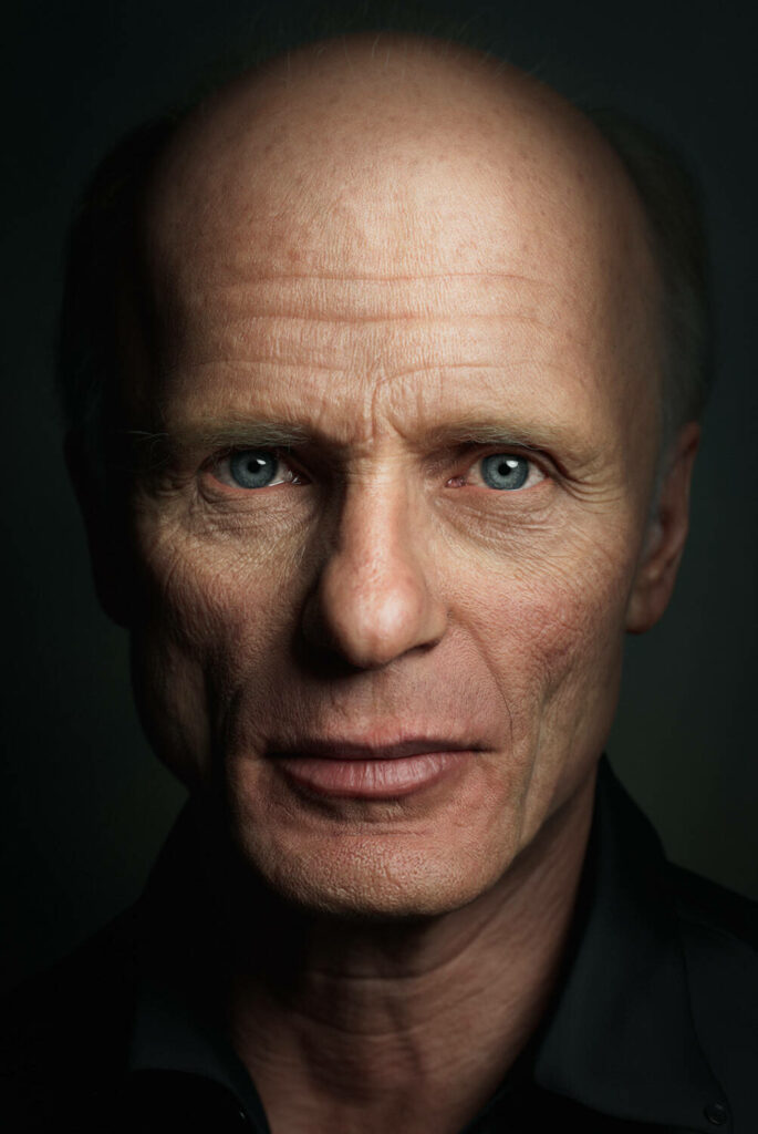 Portrait of American actor Ed Harris with dramatic lighting highlighting his blue eyes and features Wallpaper