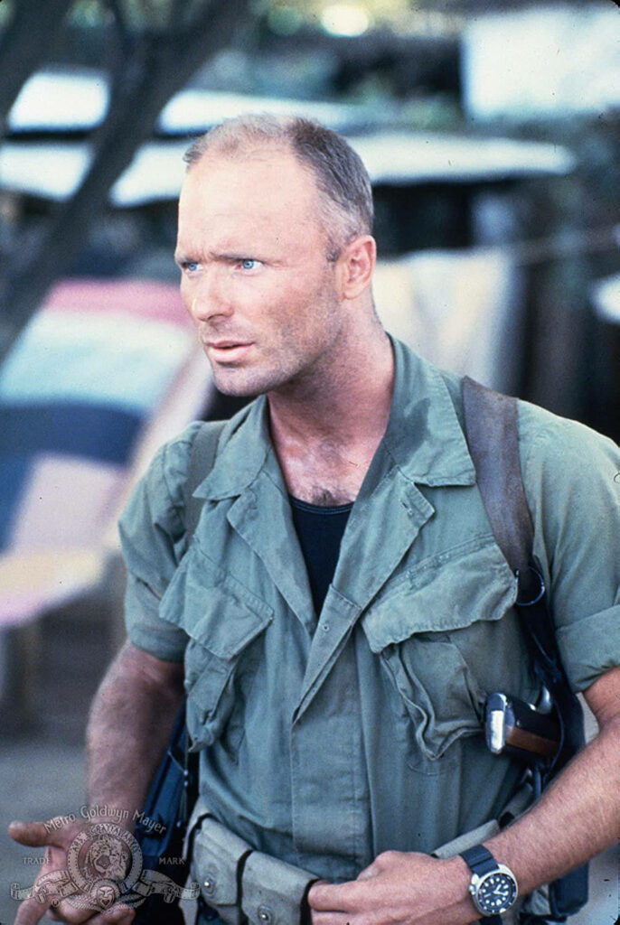 Ed Harris in military attire with intense blue eyes in Under Fire film outdoor wartime portrait Wallpaper