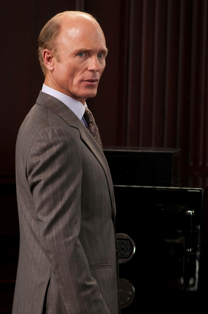 Ed Harris as Mitch Wilkinson in sharp pinstripe suit with serious expression formal dark background Wallpaper