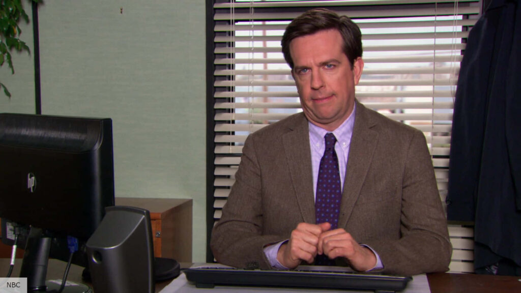 Ed Helms as Andy Bernard in The Office classic office scene with natural light and muted tones Wallpaper