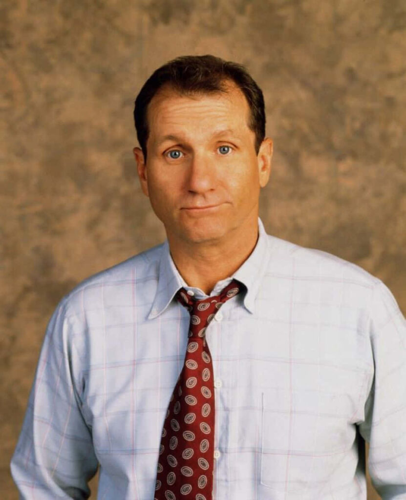 Ed O'Neill portrait wallpaper in light checkered shirt and patterned tie with textured background