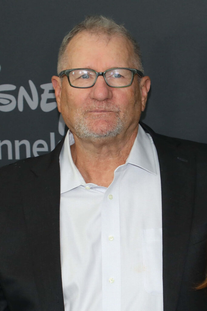 Ed O'Neill in classic suit and glasses against dark background professional timeless wallpaper