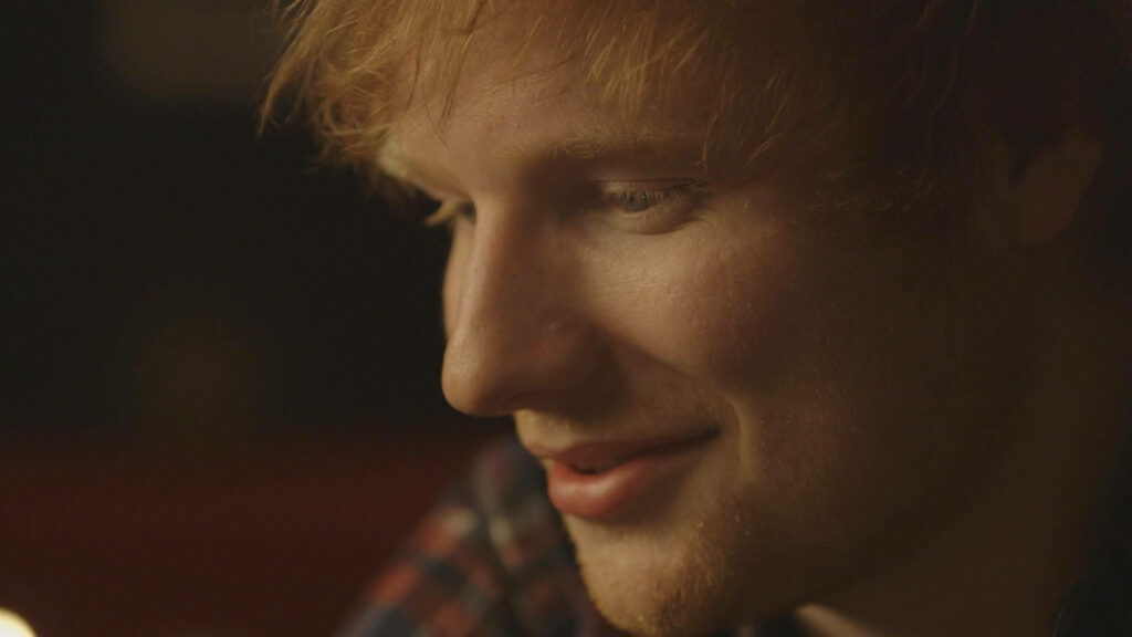Ed Sheeran Close-Up Wallpaper: Thoughtful Look & Warm Tones Background