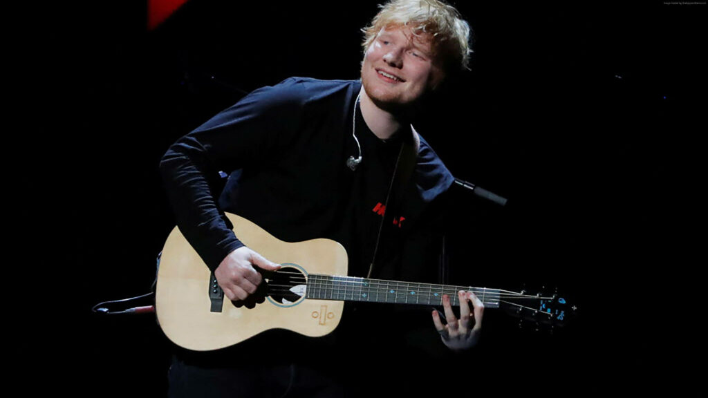Ed Sheeran's Joyful Stage Performance: Captivating Guitar Moment Wallpaper