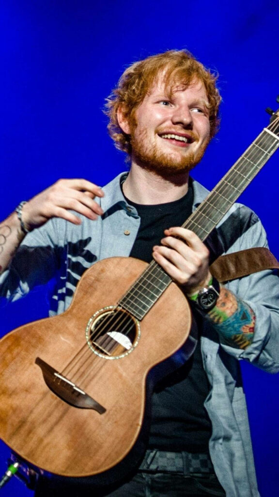 Vibrant Ed Sheeran Wallpaper: Iconic Singer with Guitar Background