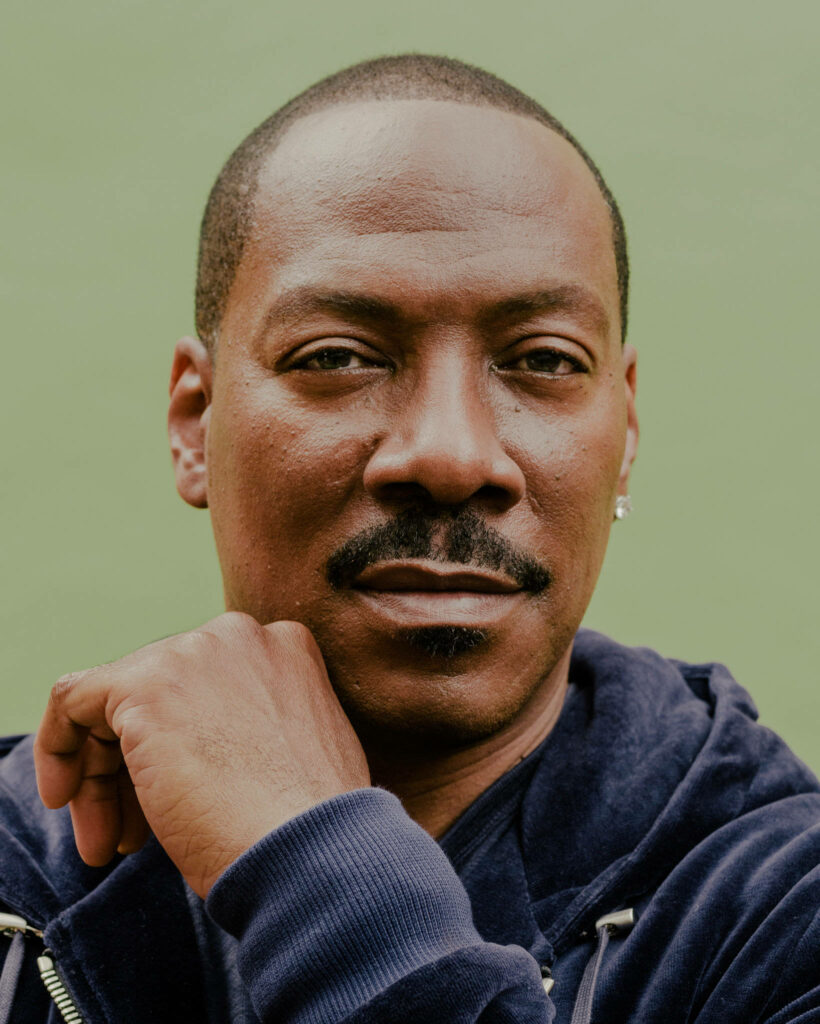Close-up portrait of Eddie Murphy 2019 with thoughtful expression soft green background wallpaper