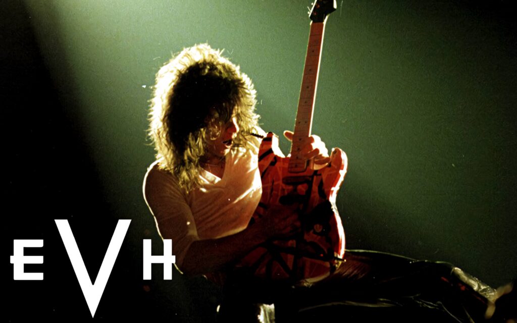 Eddie Van Halen performing live with red striped guitar and EVH logo vibrant rock wallpaper background