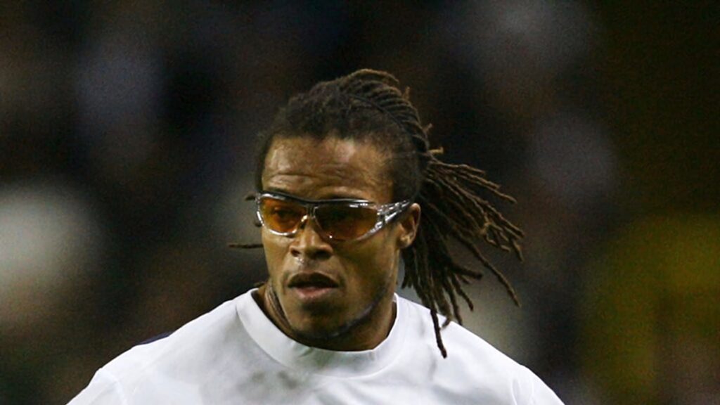 Edgar Davids in action with dreadlocks and sports goggles intense focus stadium background Wallpaper