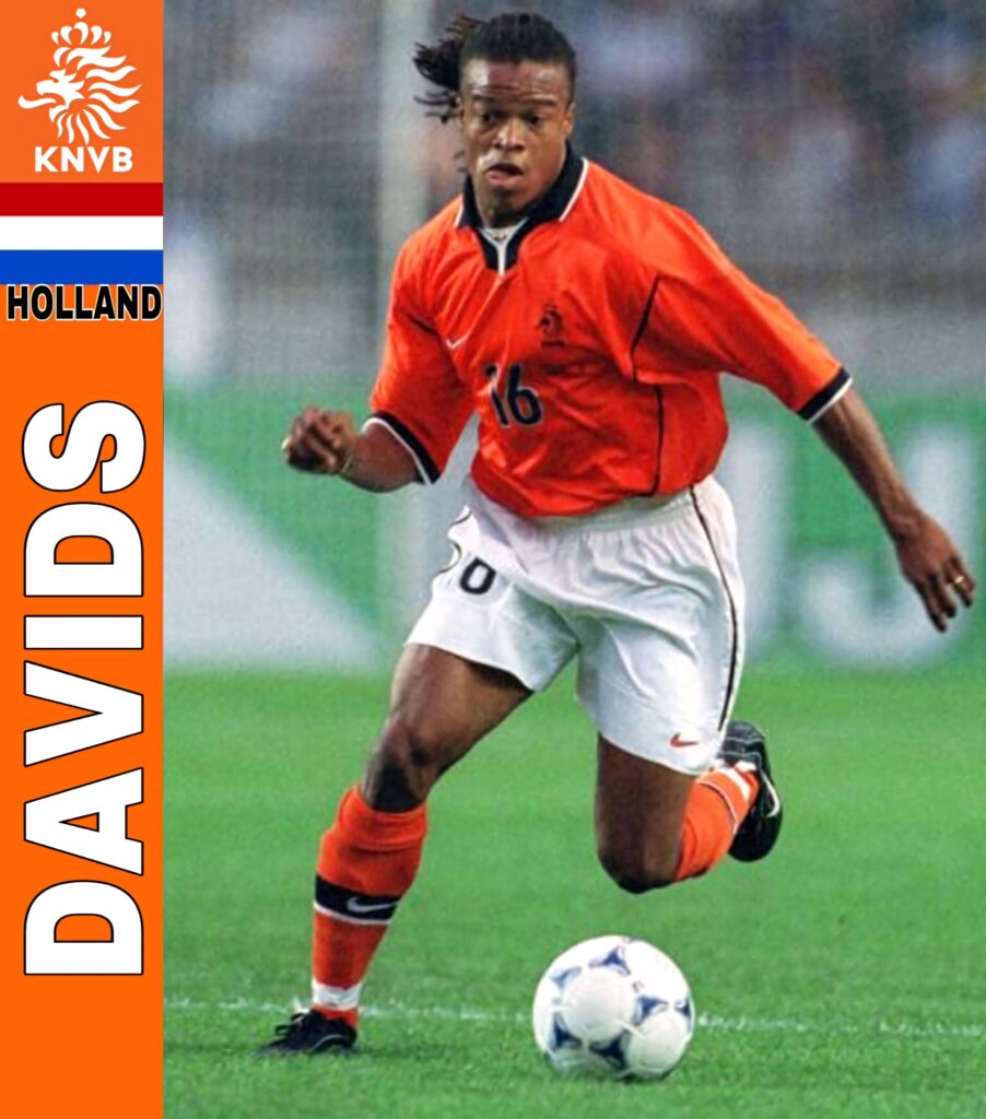 Edgar Davids in orange Holland kit showing skill and intensity with KNVB emblem background Wallpaper