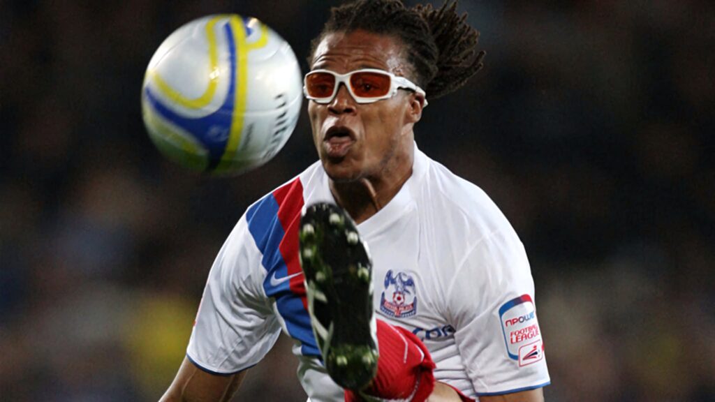 Edgar Davids in Netherlands soccer uniform with tinted goggles captured in dynamic action pose Wallpaper