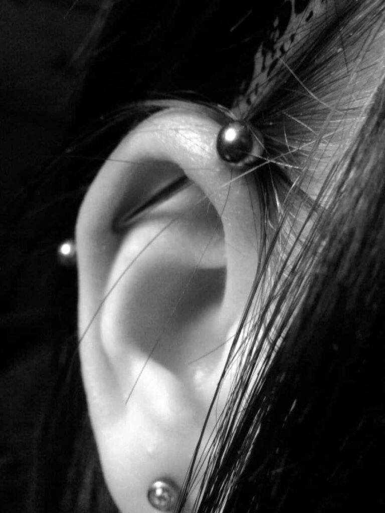 Close-Up Black & White Ear Piercings - Edgy Body Art Wallpaper