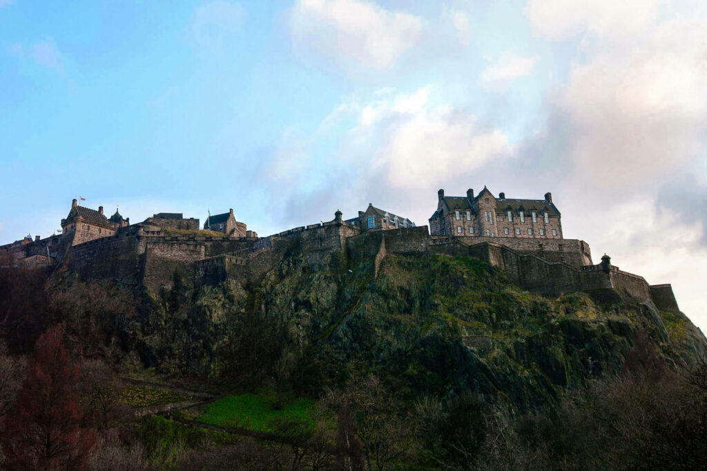 Edinburgh Castle on Castle Rock with historic stone walls and cloudy sky panoramic wallpaper