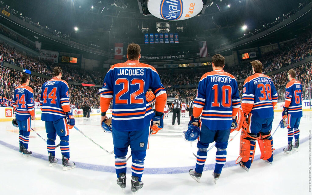Edmonton Oilers hockey team lined up on rink in blue orange uniforms NHL arena packed with fans Wallpaper