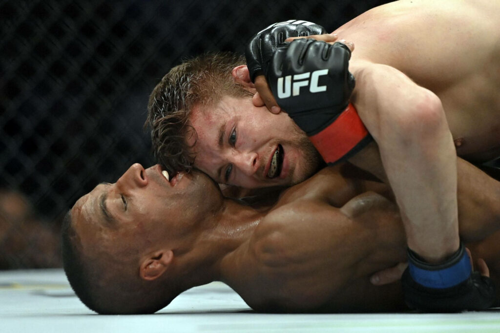 UFC fighter Edson Barboza tackled during intense MMA match showcasing athletic grappling action Wallpaper