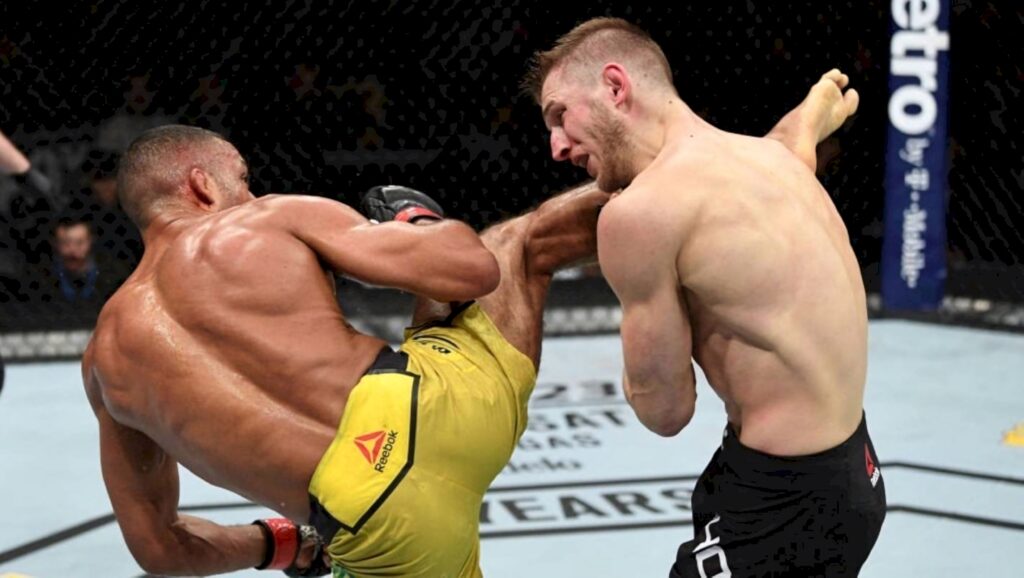 Edson Barboza powerful kick to Dan Hooker UFC octagon intense MMA action vibrant colors wallpaper