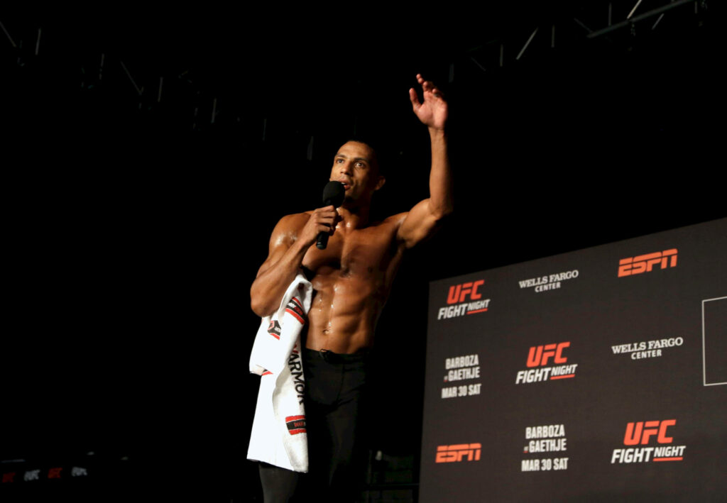Edson Barboza shirtless on UFC Fight Night stage holding microphone and towel post-fight interview Wallpaper