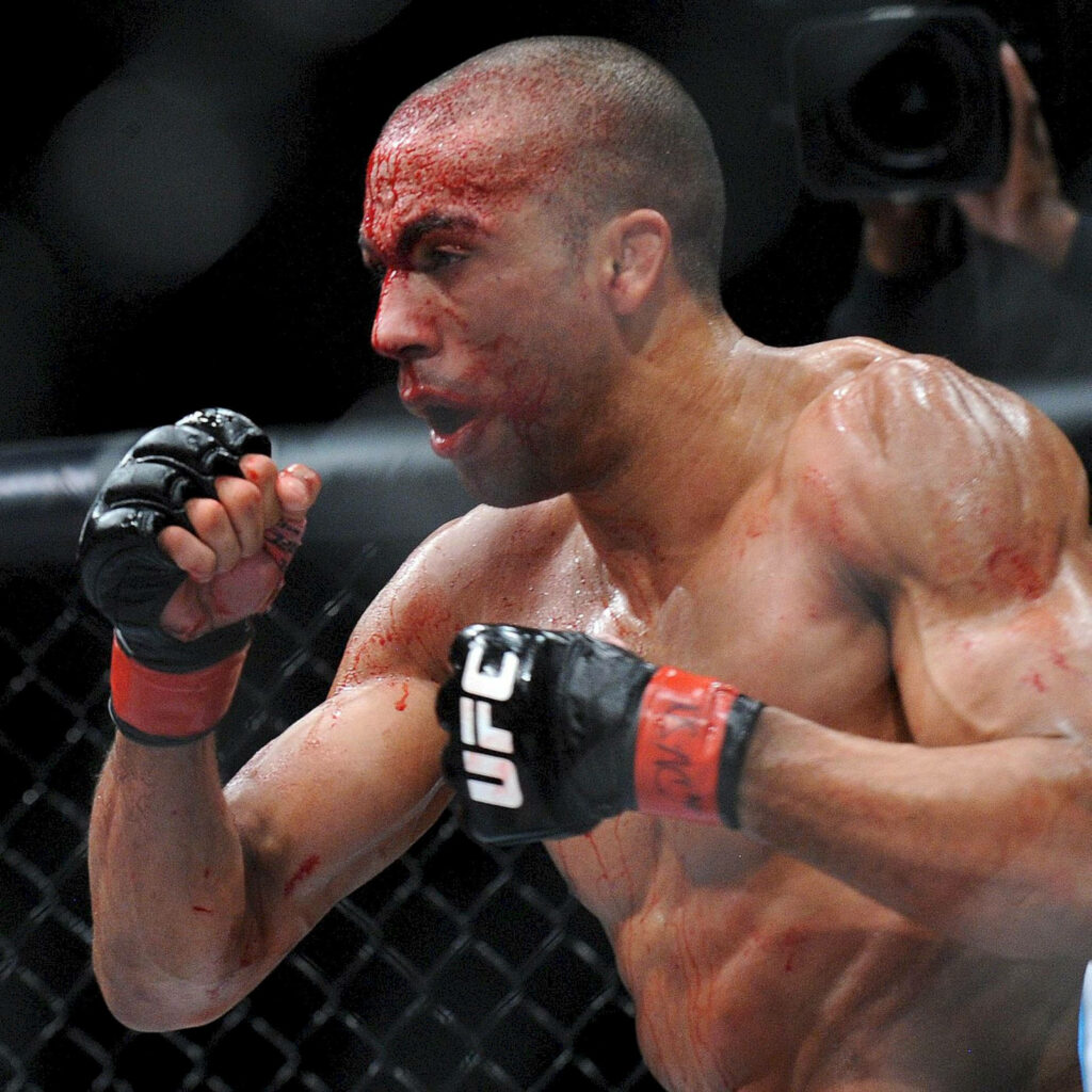 Edson Barboza in octagon with bloodied face showing MMA fight intensity and determination Wallpaper