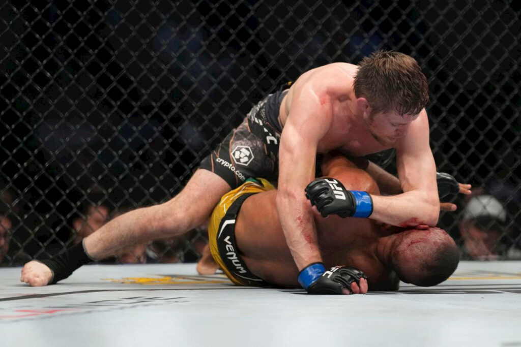 Edson Barboza and Bryce Mitchell intense MMA fight grappling inside octagon cage wallpaper background