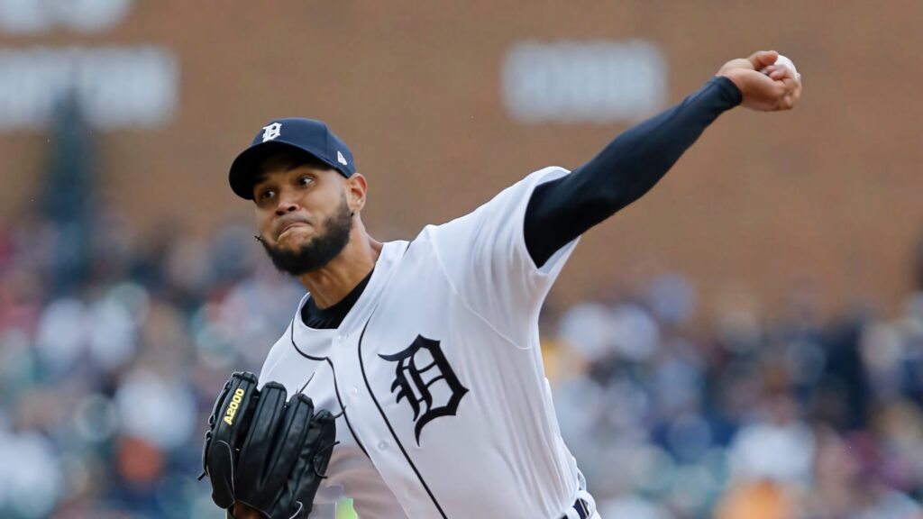 Eduardo Rodríguez pitching for Detroit Tigers in white navy uniform with blurred stadium background Wallpaper