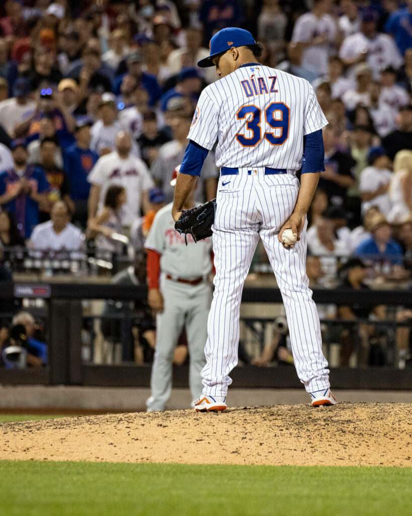 Edwin Diaz pitching in New York Mets pinstripe uniform with vibrant stadium crowd background Wallpaper