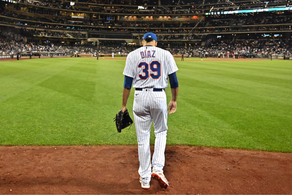 Edwin Diaz in number 39 pinstripe uniform stepping onto field under lights with focused expression Wallpaper