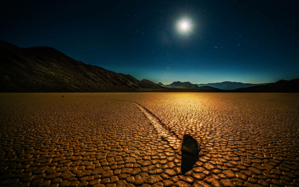 Eerie Racetrack Playa Wallpaper: Mystical Stones Under Starry Sky