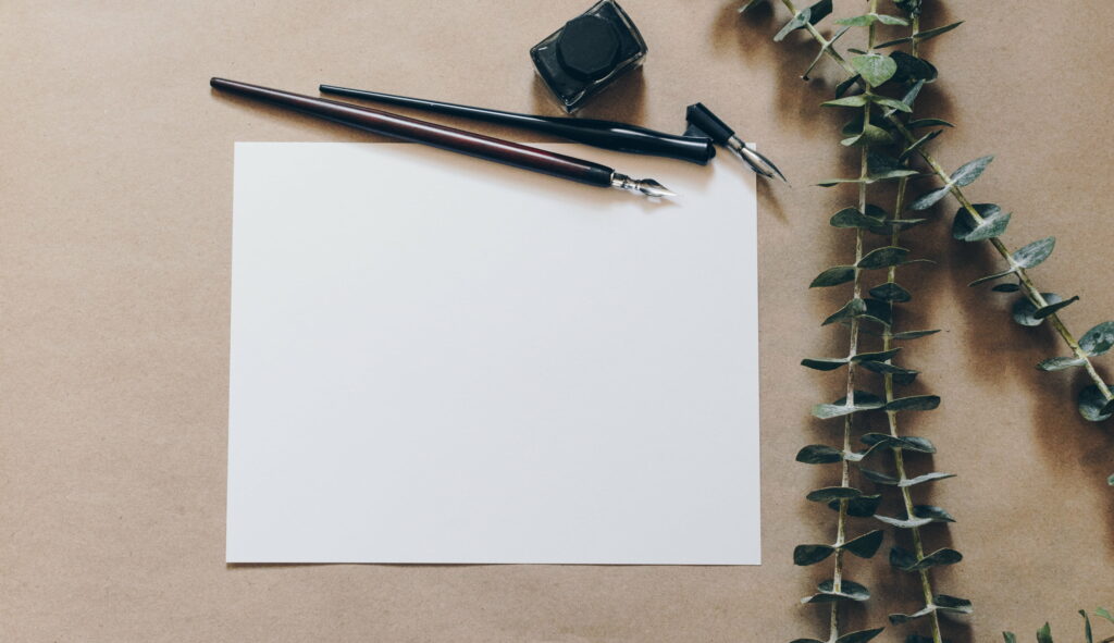 Creative Workspace: Pens and Printer Paper on QHD Wallpaper