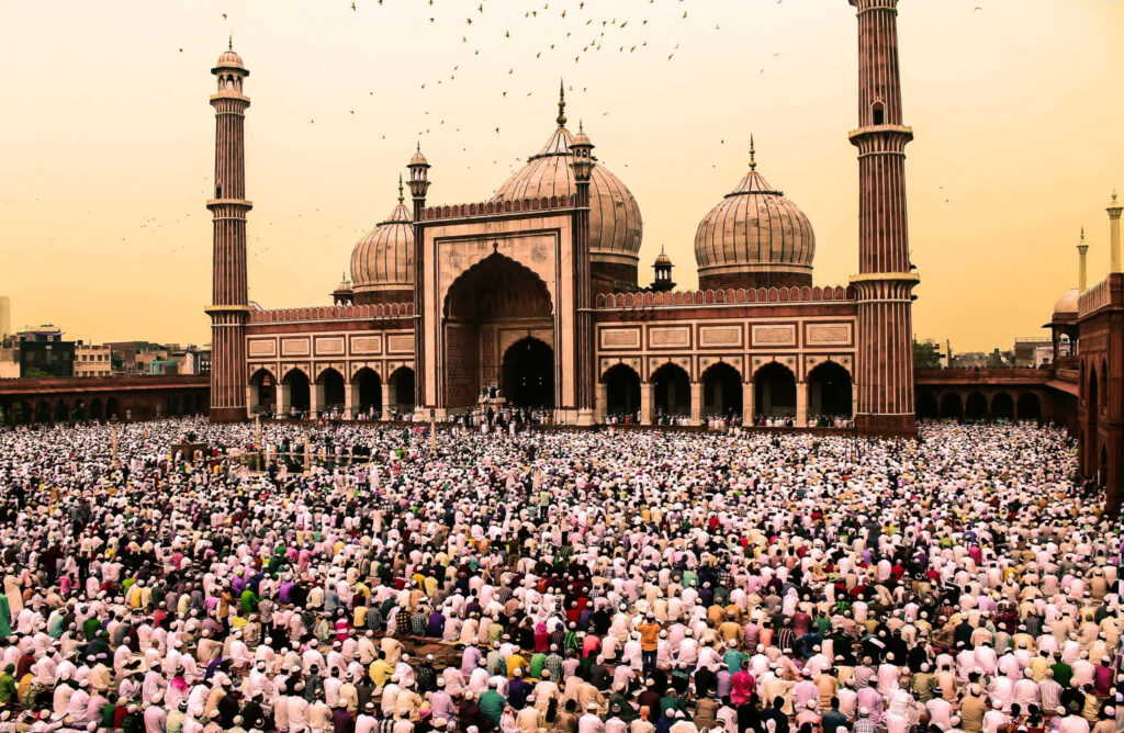 Eid worshippers gathering at grand mosque with golden sunset sky vibrant Islamic architecture wallpaper