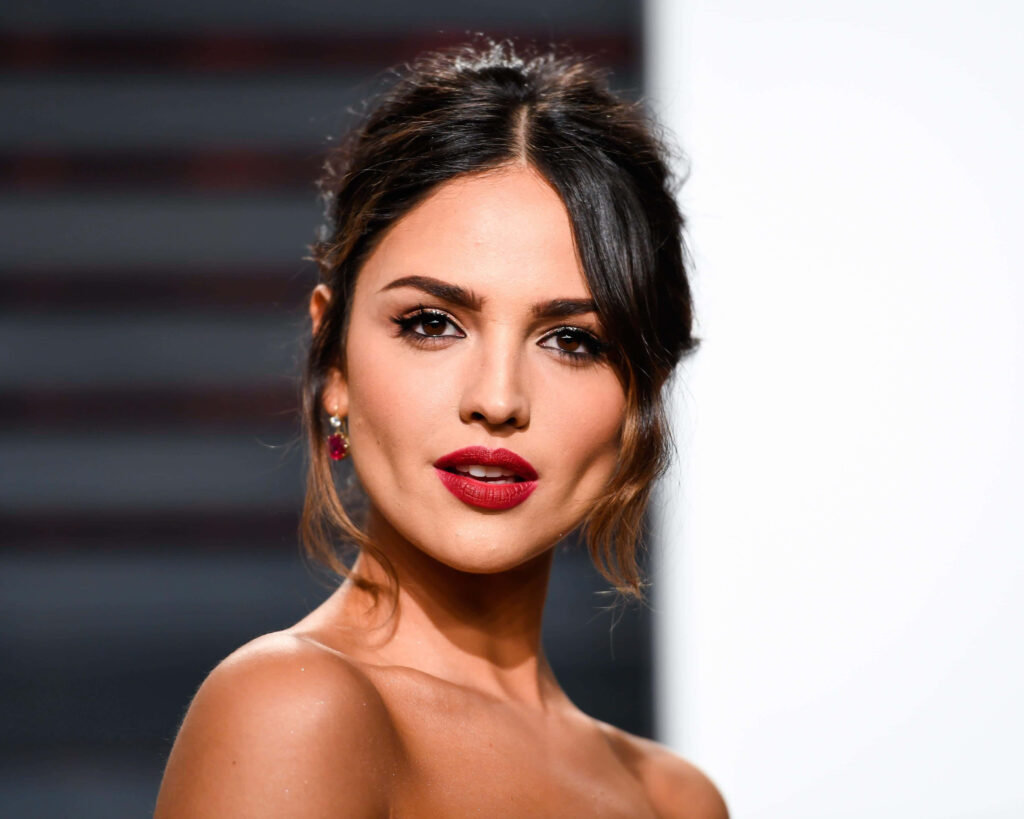 Eiza González portrait with glamorous makeup bold red lips soft waves minimalist background Wallpaper