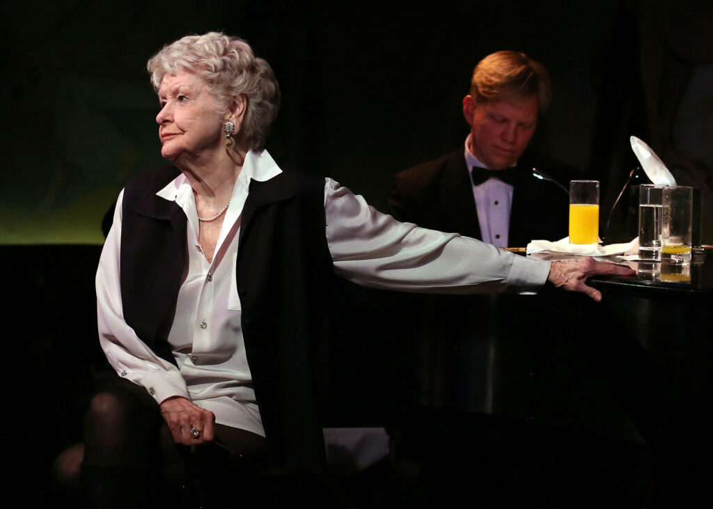 Elaine Stritch center stage mid performance dramatic pose vintage theater lighting wallpaper background