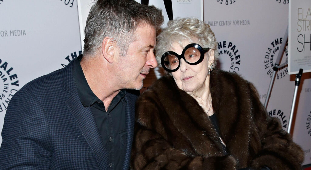 Actress Elaine Stritch and actor Alec Baldwin share a friendly moment at event with wallpaper background