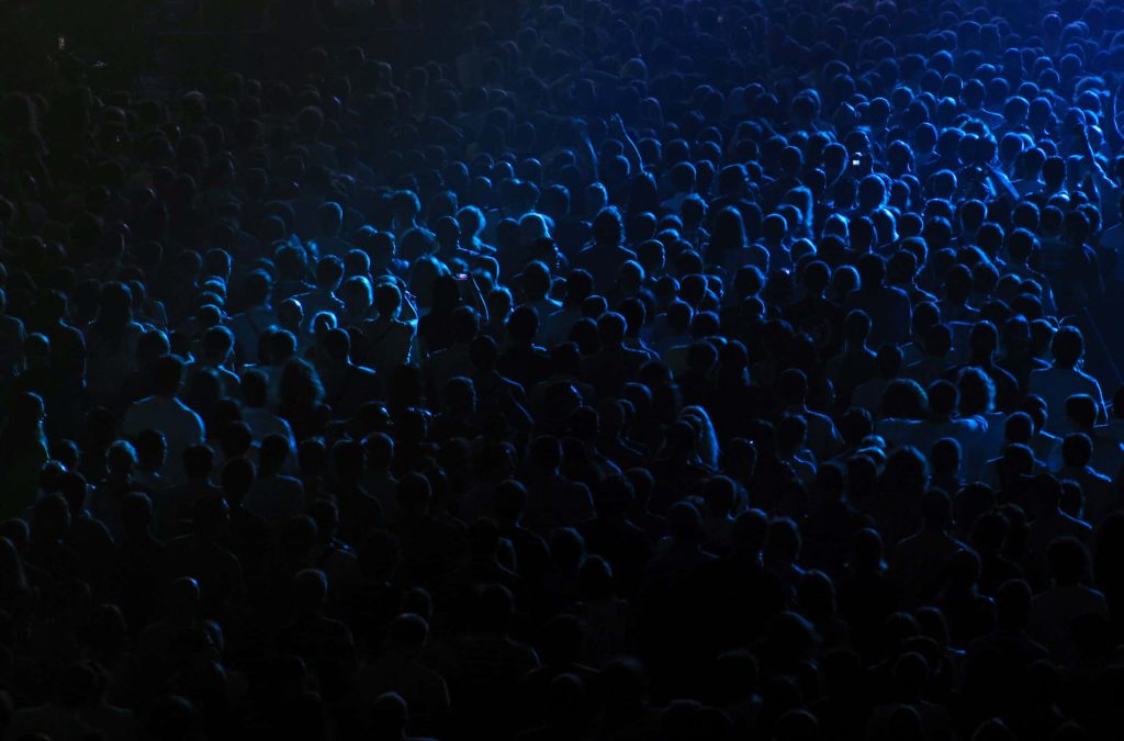 High-angle concert view with silhouetted crowd and moody blue lighting live music wallpaper
