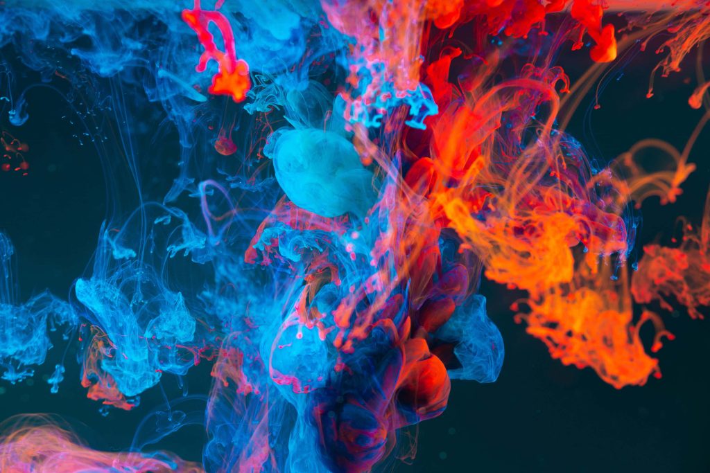 Vibrant fluid art wallpaper with electric blue and fiery red ink swirling in dark water background