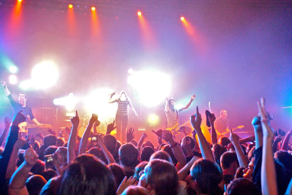 Vibrant live rock concert with colorful stage lights and crowd cheering for guitar solo performance Wallpaper