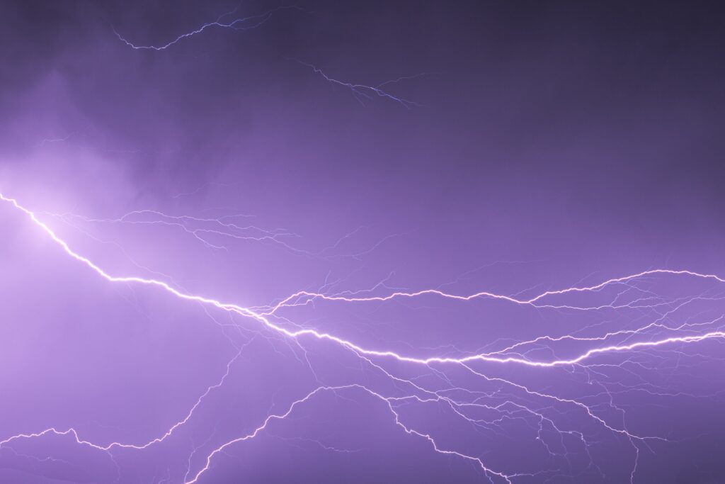 Stormy sky with vibrant purple lightning bolts creating an electric dramatic nature scene wallpaper