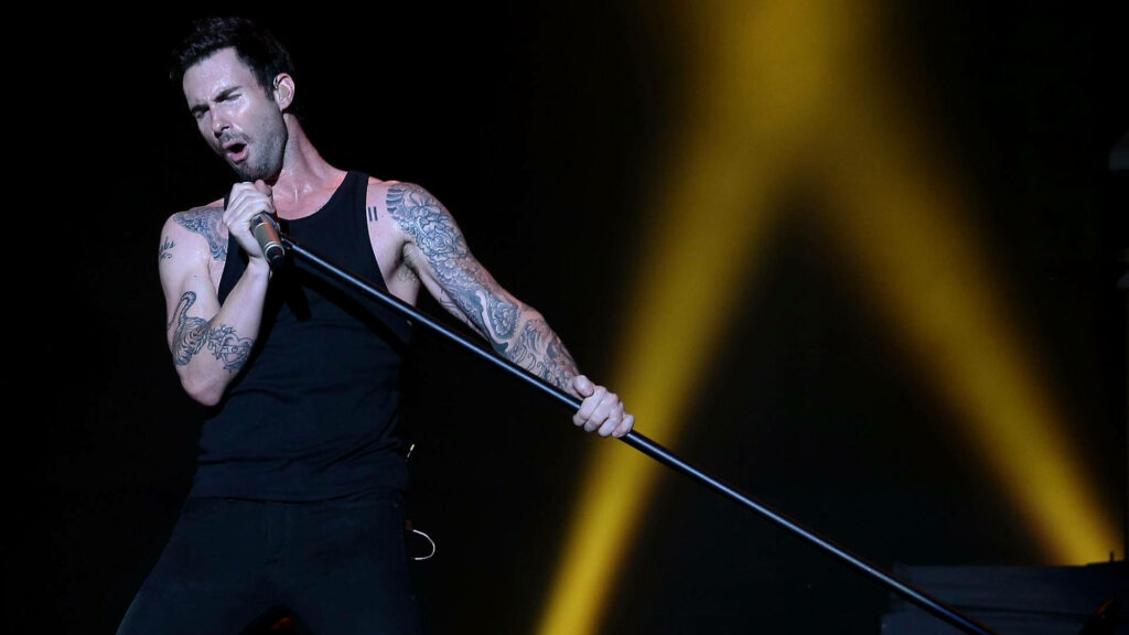 Adam Levine live performance wallpaper: vibrant energy, iconic tattoos, powerful charisma.