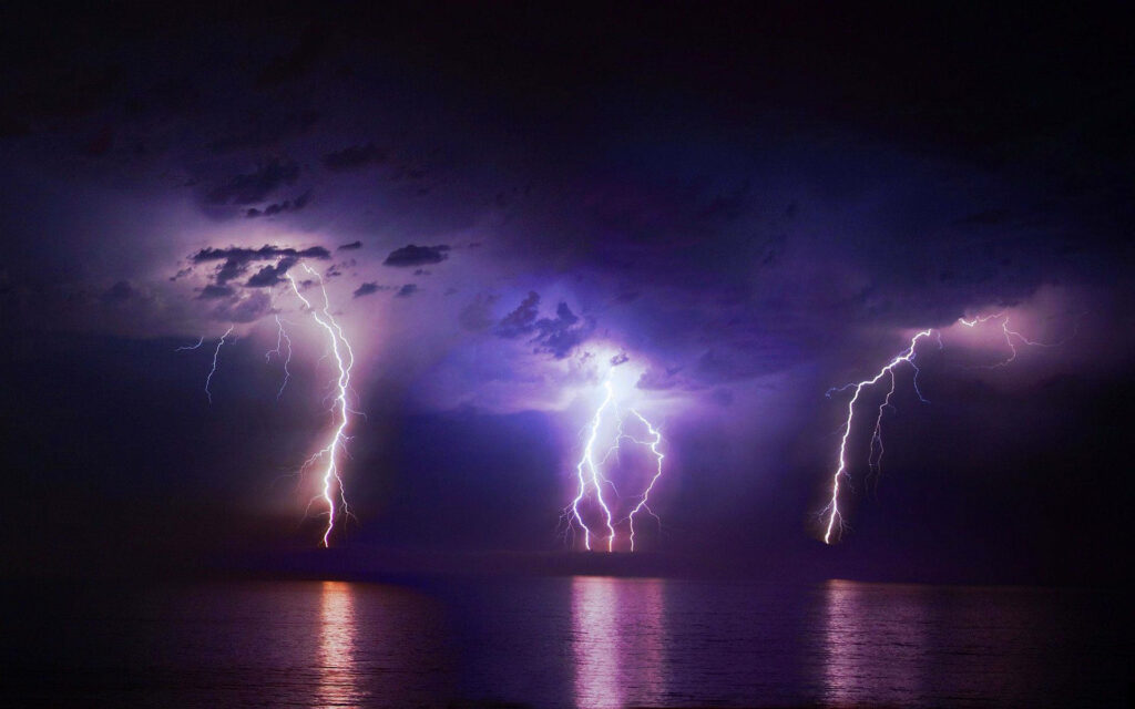 The Dazzling Symphony of Nature: Lightning's Brilliant Dance across the Ocean's Serene Canvas Wallpaper
